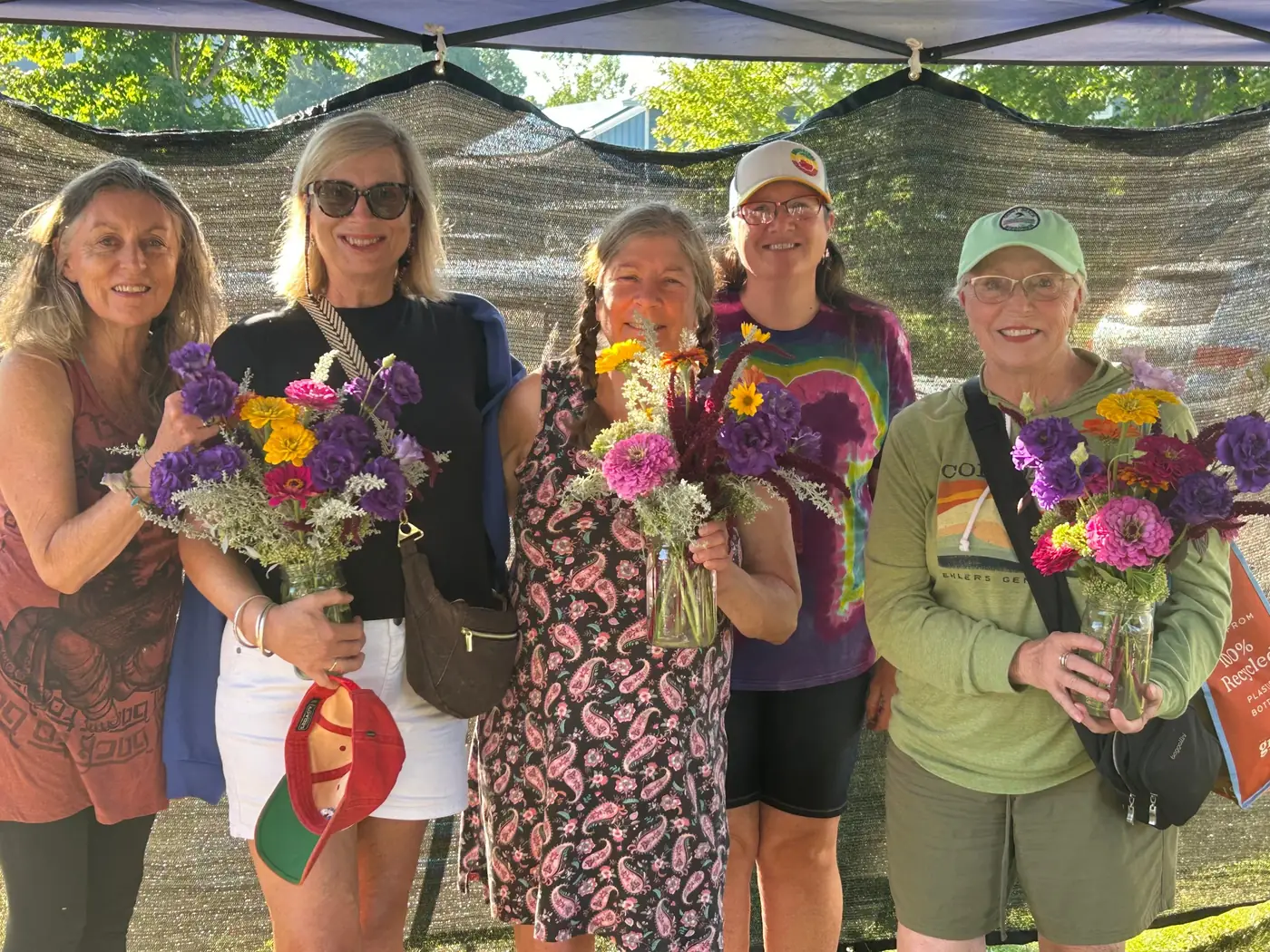 Owner Mary Pearson, center, and farm manager Heather Szarka with customers holding Silver Sage bouquets at the farmers' market